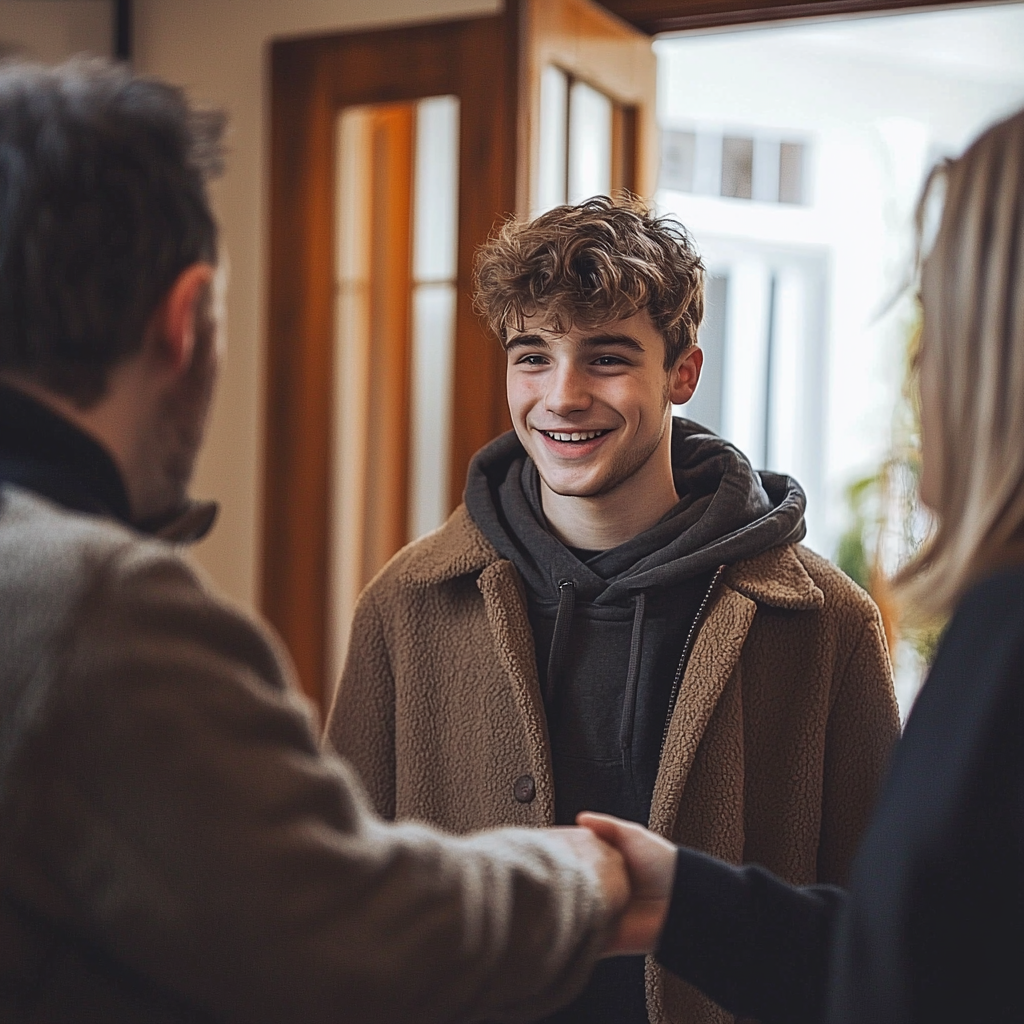 family member (son) being welcomed into a house by two older people (mum & dad)