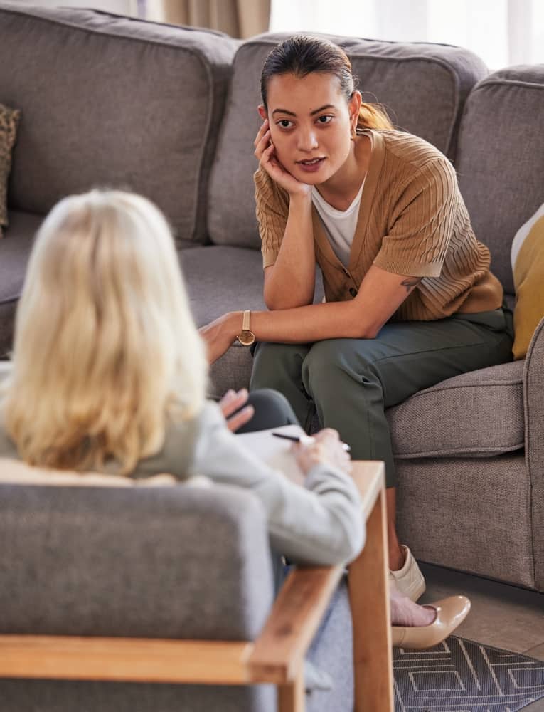 A therapy session with two people sat facing each other and talking.