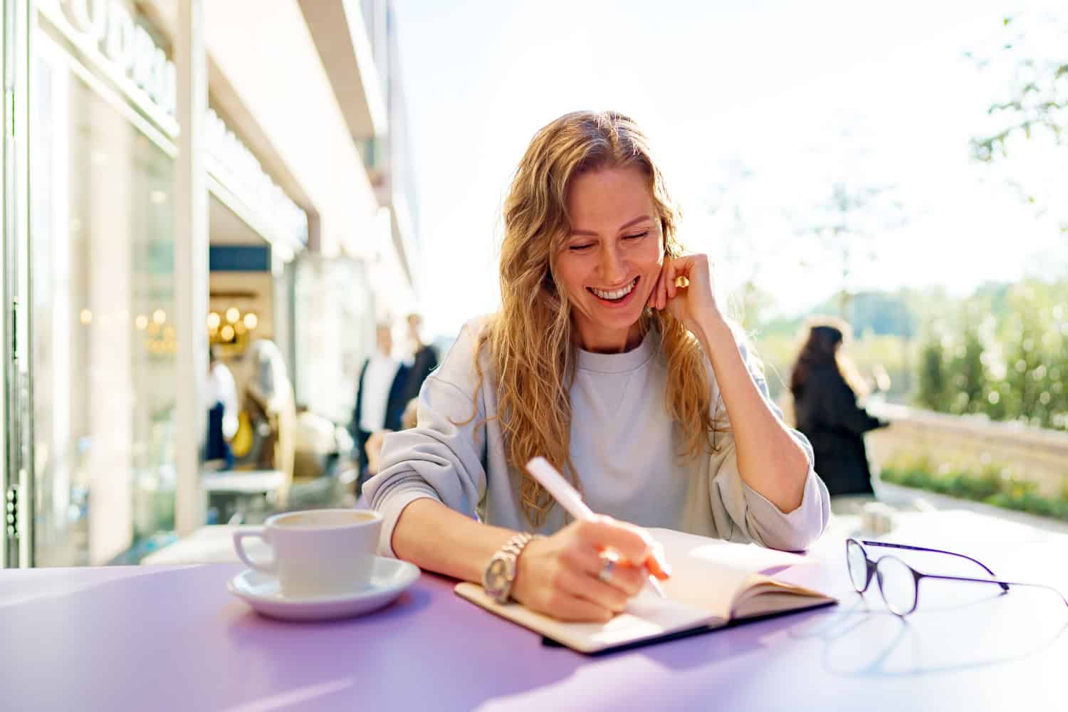woman sitting in restaurant and writing on a journal